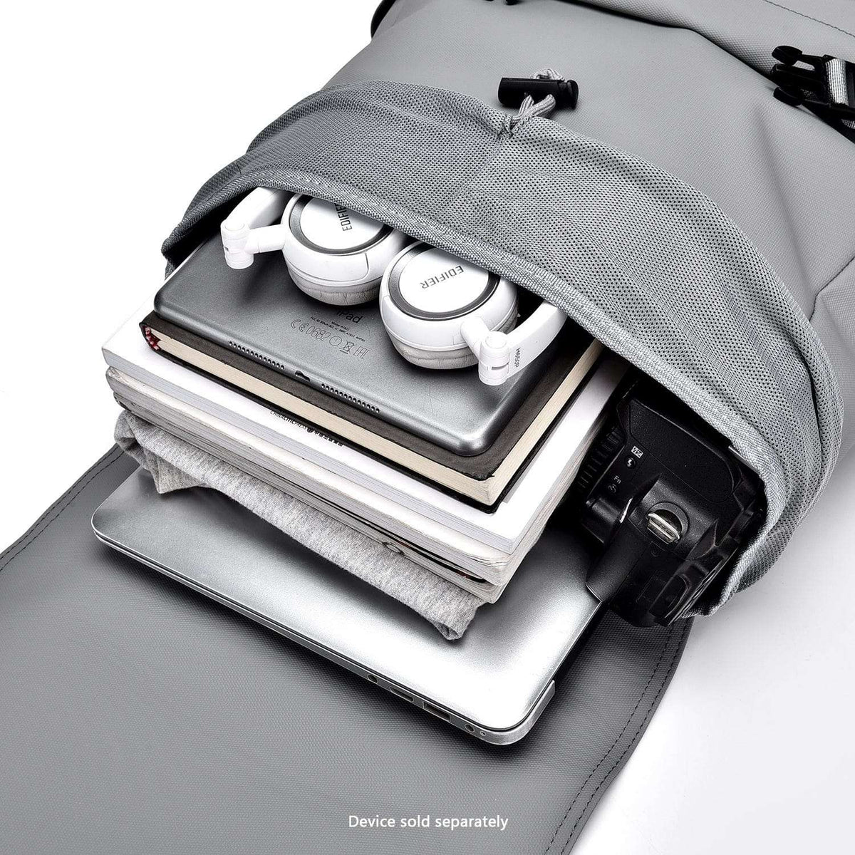Cool gray laptop backpack open compartment holding books, headphones, and chargers.