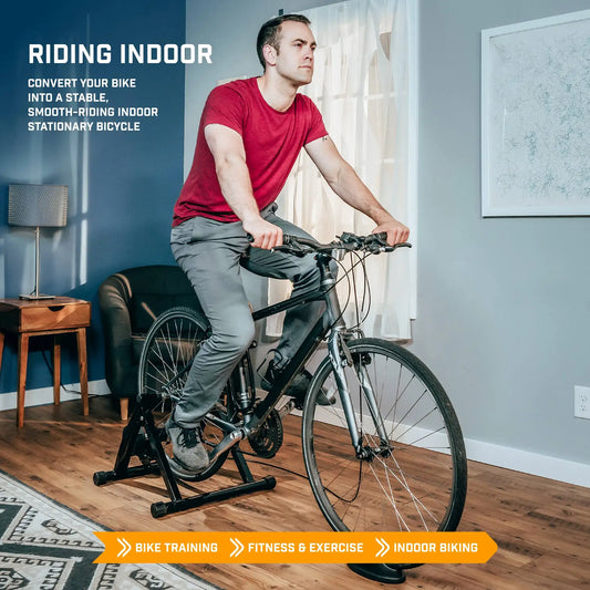 Cyclist using magnetic bike trainer stand with road bicycle in indoor riding position