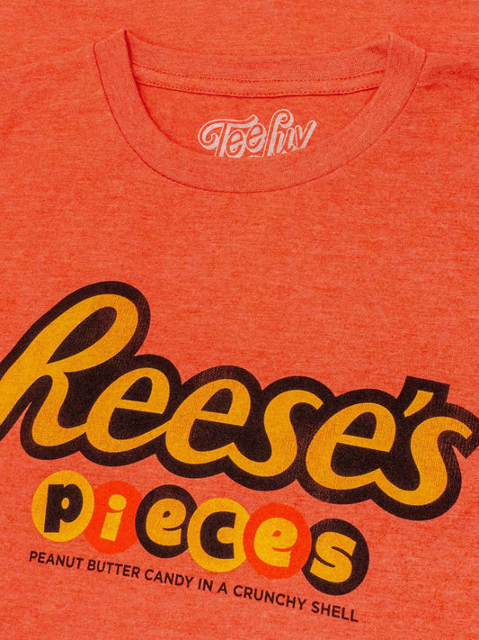 Orange heather T-shirt close-up of Reese's Pieces logo and peanuts text