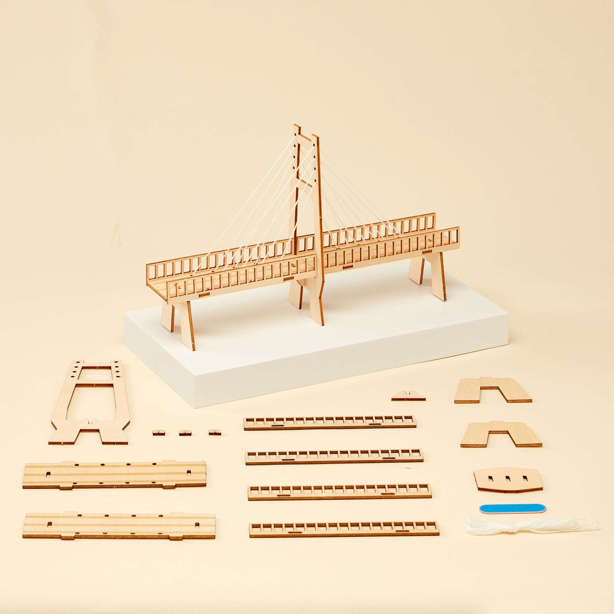 Cable-stayed bridge model kit parts and bridge frame pieces on a base