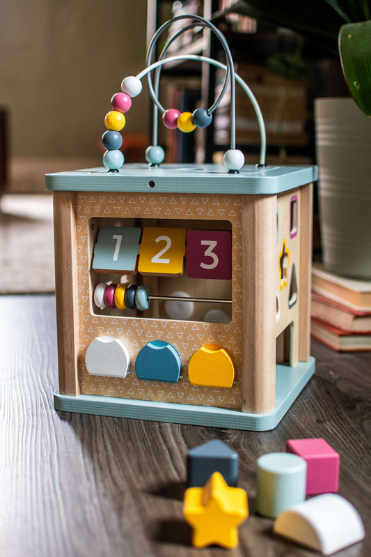 Wooden activity cube with number tiles 1–3, bead maze and dangling rods