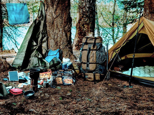 1-person survival backpacking kit campsite setup with backpacks, solar panel, and stove