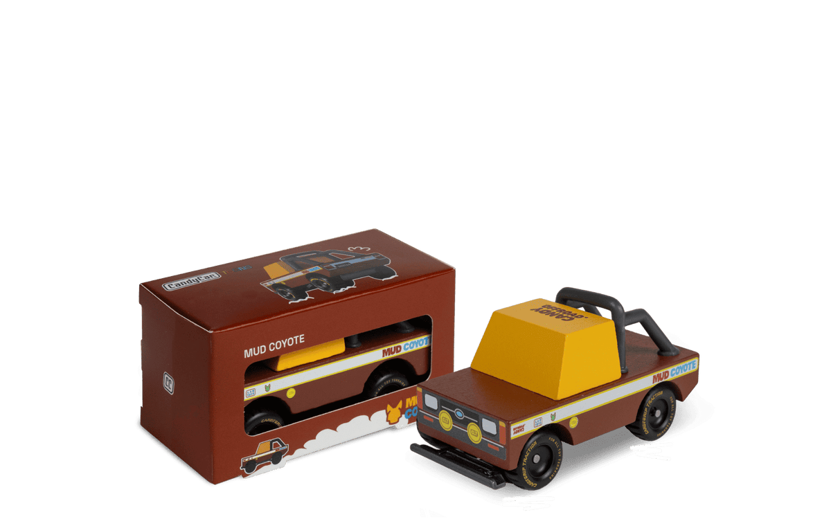 Brown toy box and small brown-and-yellow off-road truck toy with Coyote graphic