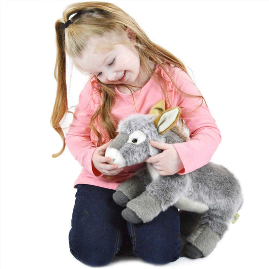Gray donkey plush held by a child in a pink long-sleeve shirt.
