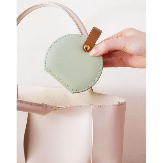 Mint green round jewelry organizer with tan handle, shown closed by a top strap