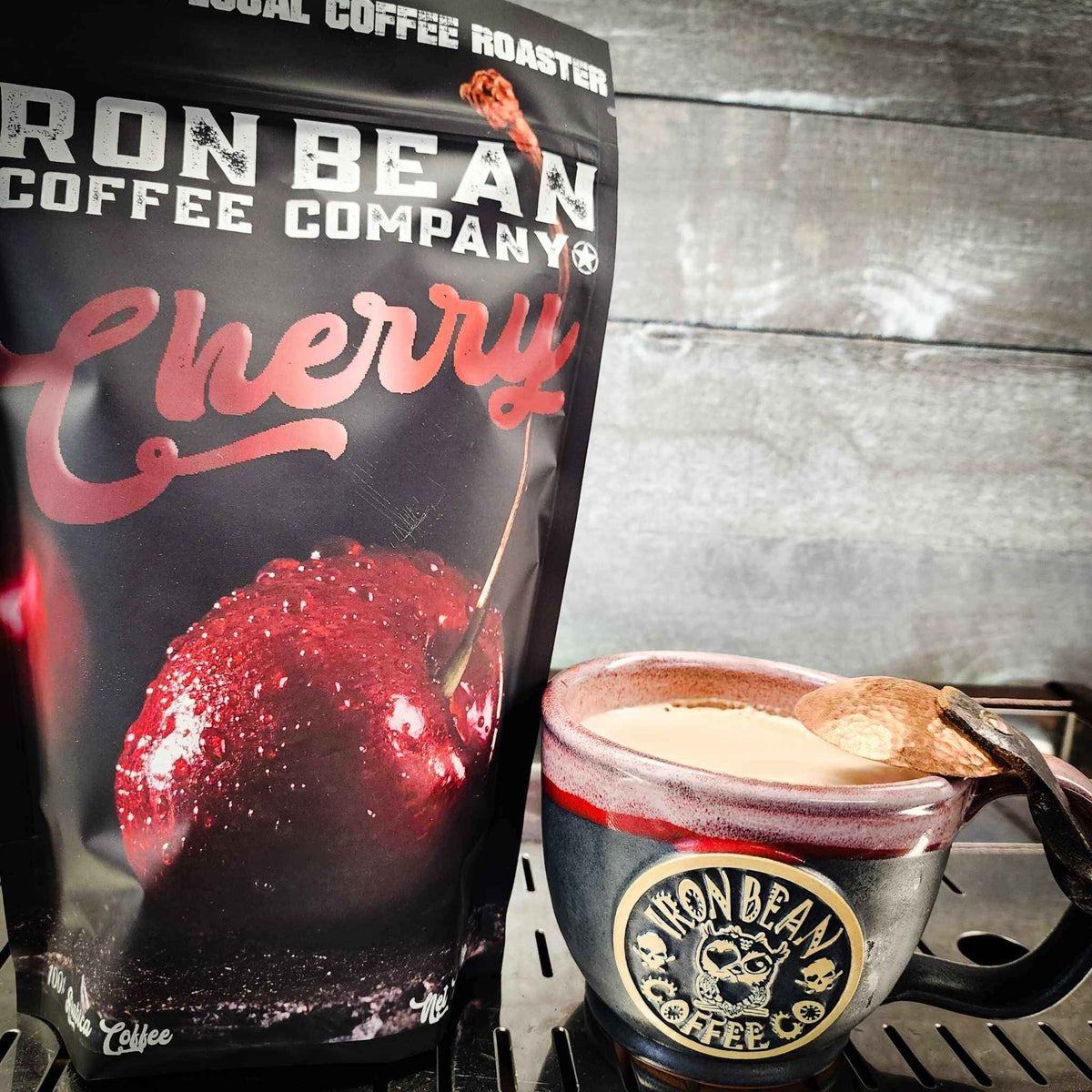 Cherry-flavored coffee bag beside a mug of coffee with light foam