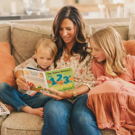 Toddler picture book with green cover showing big 123 and Helping, held by child