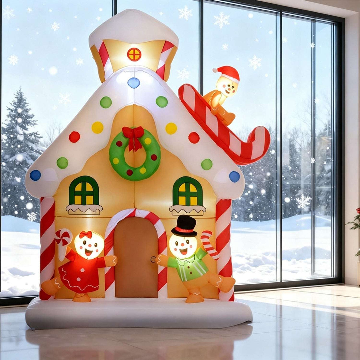 Front view of an inflatable gingerbread house with candy trim, wreath and two gingerbread figures
