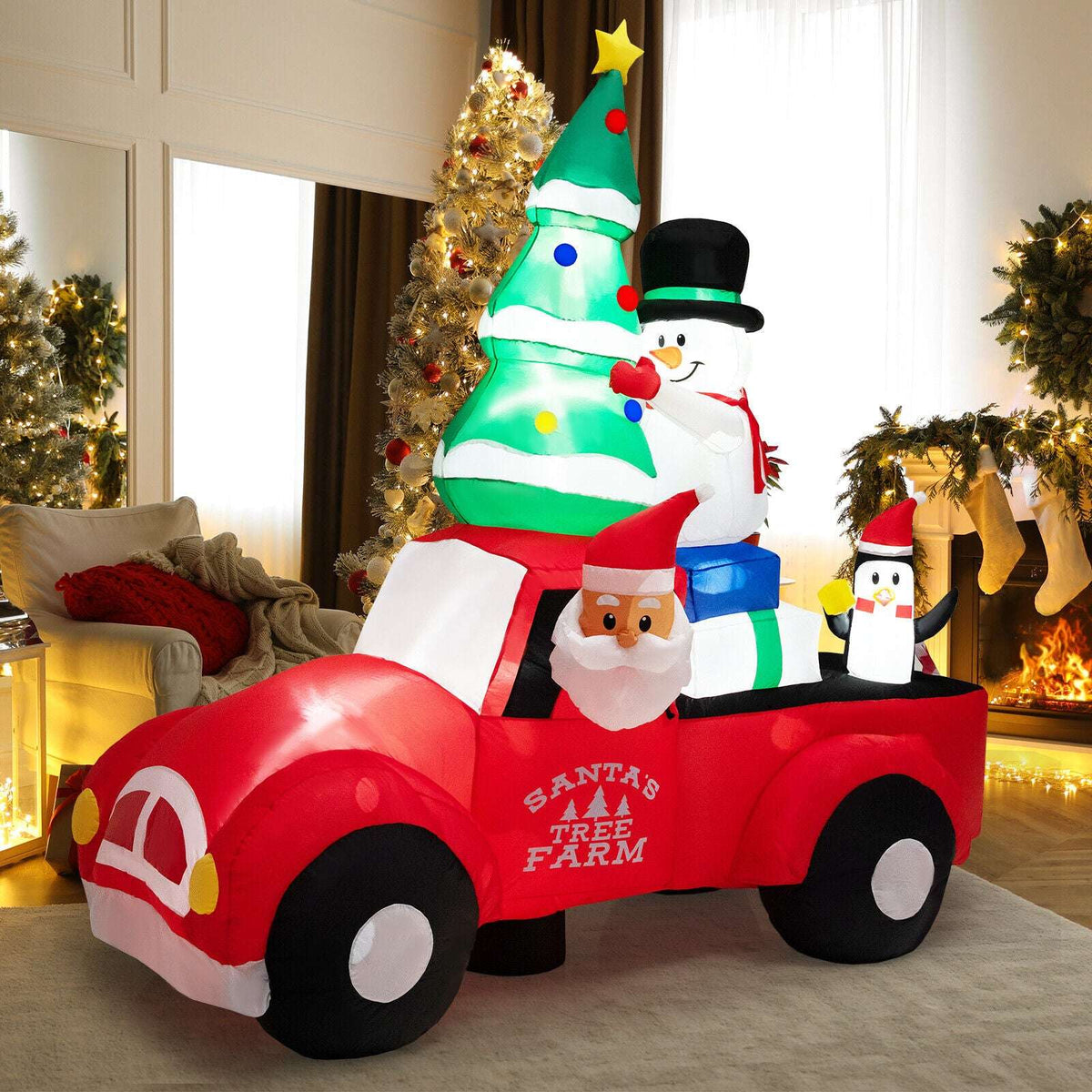 Inflatable red Christmas pickup with Santa, a tree, snowman and penguin figures.