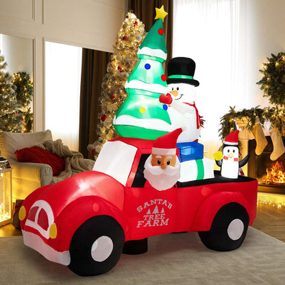 Inflatable red Christmas pickup with Santa, a tree, snowman and penguin figures.