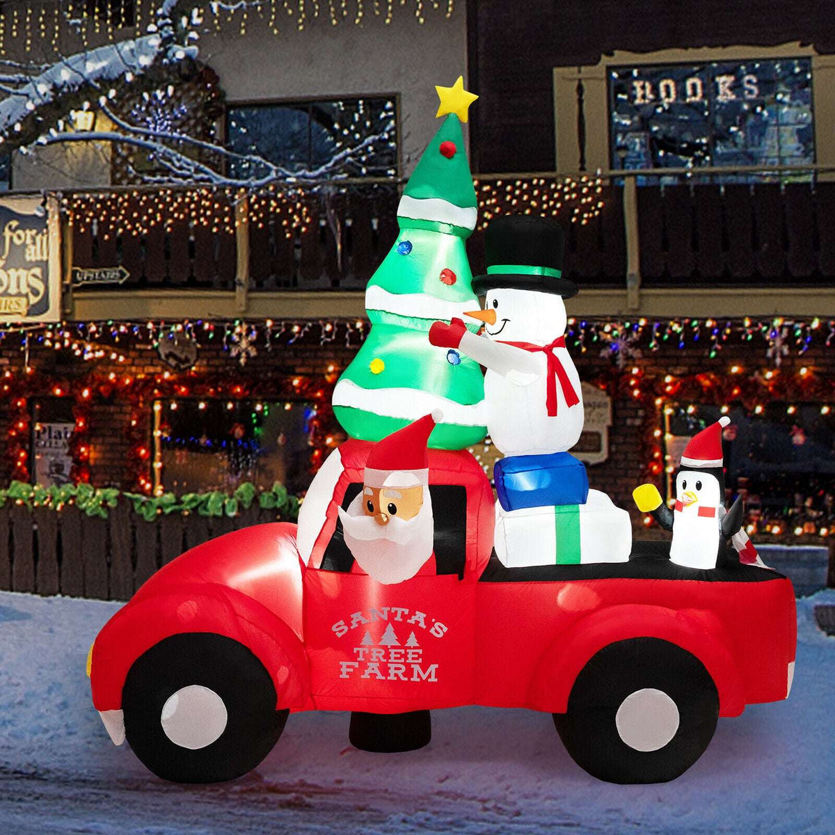 Inflatable red Christmas pickup with Santa, tree, snowman and penguin figures; LED lights glow.