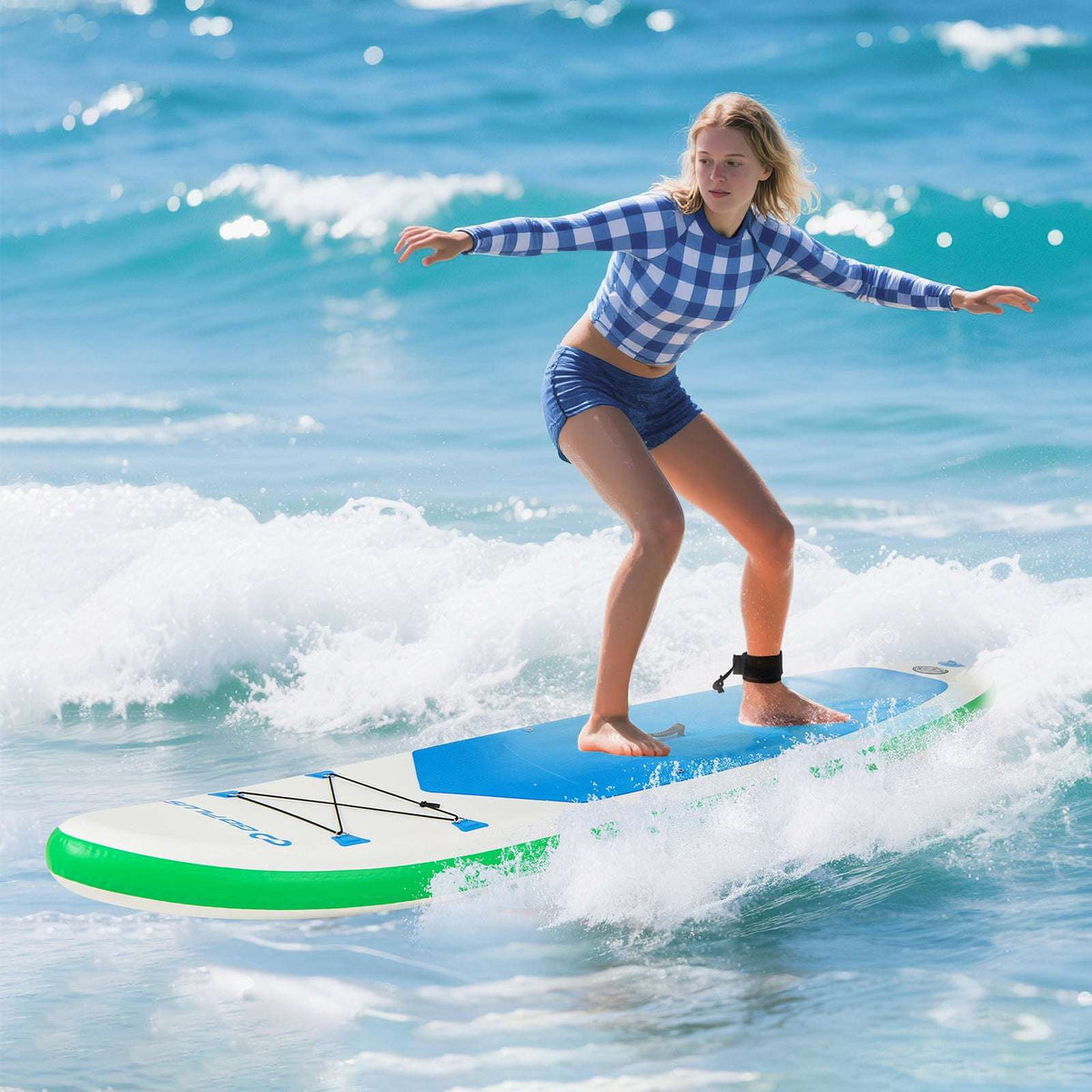 Inflatable paddle board with blue deck pad and green trim, shown riding a wave