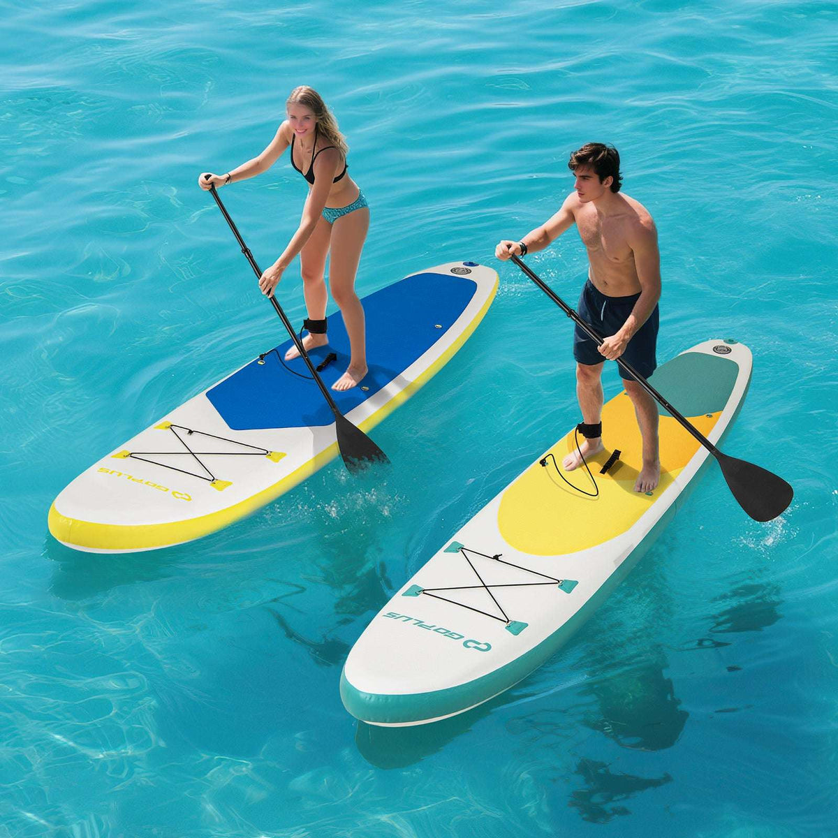 Two inflatable paddle boards with blue and yellow deck panels, each ridden with a paddle