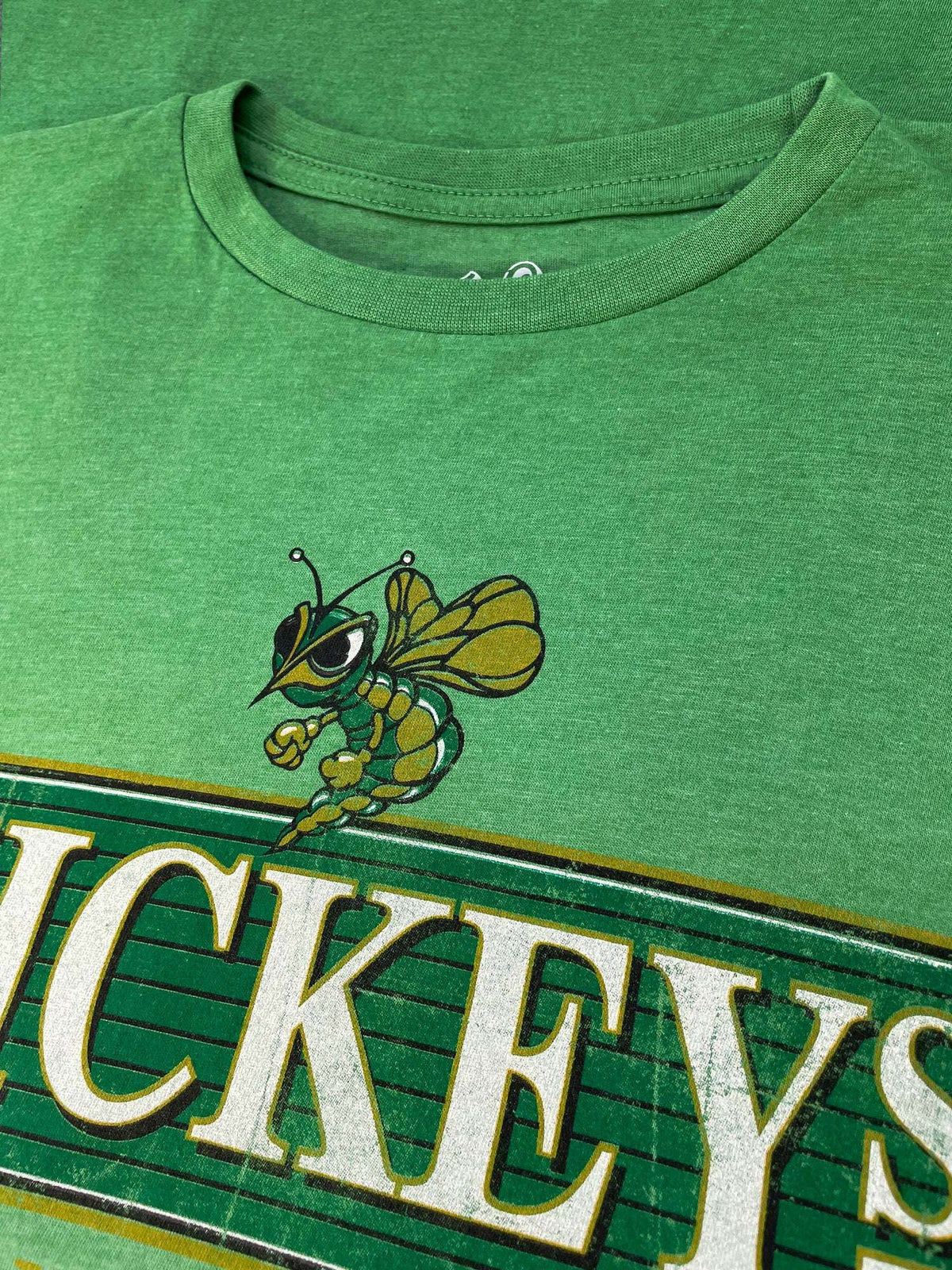 Green T-shirt close-up of malt liquor logo lettering and bee graphic