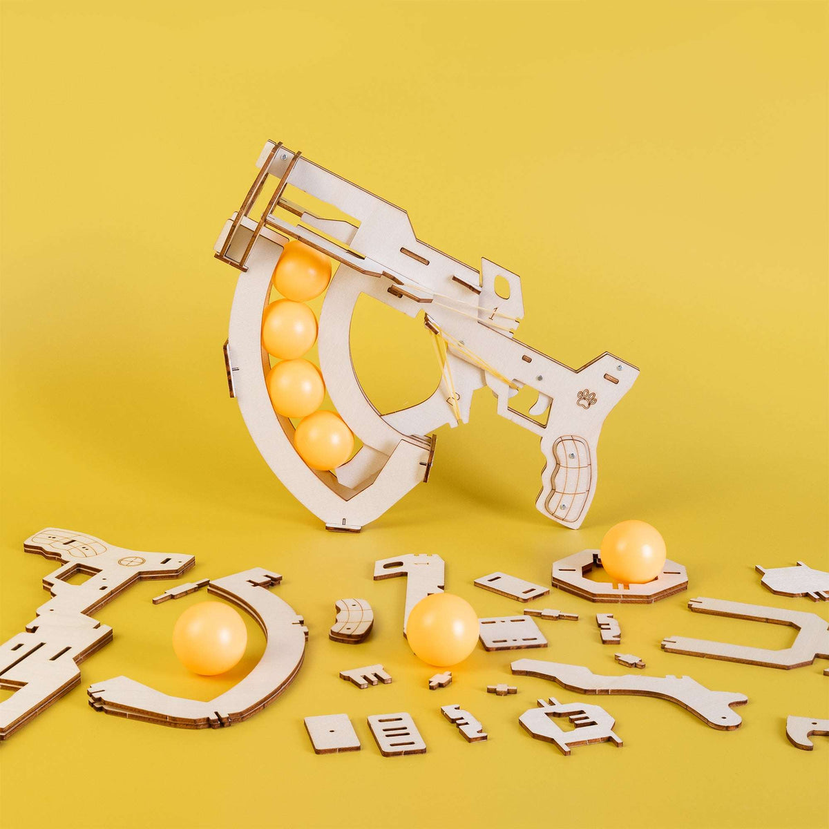 Wooden ball launcher kit with orange balls and flat wooden assembly pieces