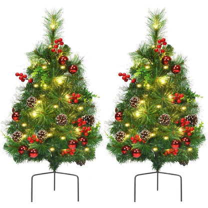 Pair of illuminated Christmas trees decorated with red berries, red ornaments, and pine cones