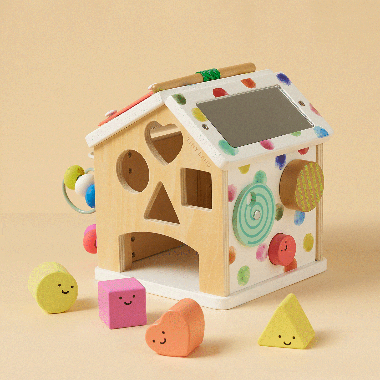 Wooden activity cube with shape cutouts, colorful knobs, and safety mirror panel
