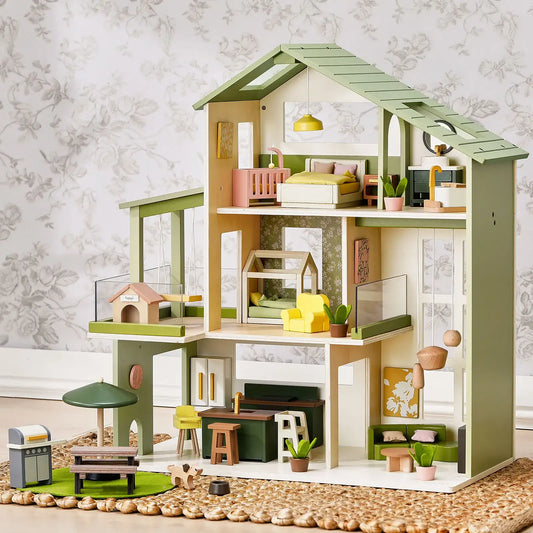 Green and pink wooden dollhouse with multi-level rooms and furniture accessories
