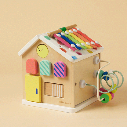 Wooden activity cube with rainbow xylophone top, smiling face door, and wire bead maze
