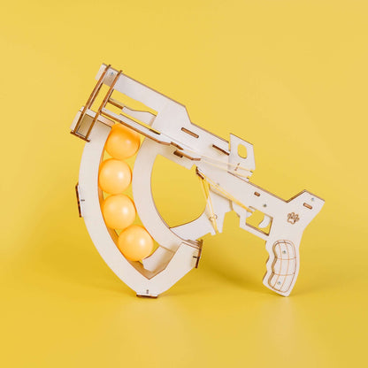 Wooden ball launcher kit with orange balls and pistol-style grip handle