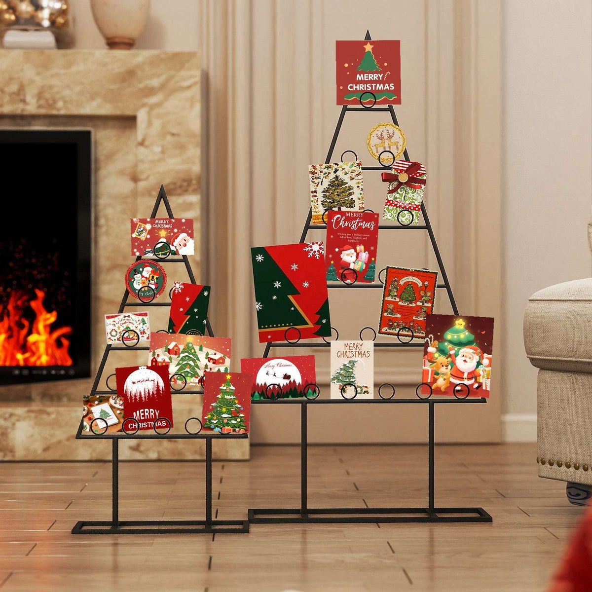 Two black metal Christmas tree card holders in different sizes, displaying holiday cards.