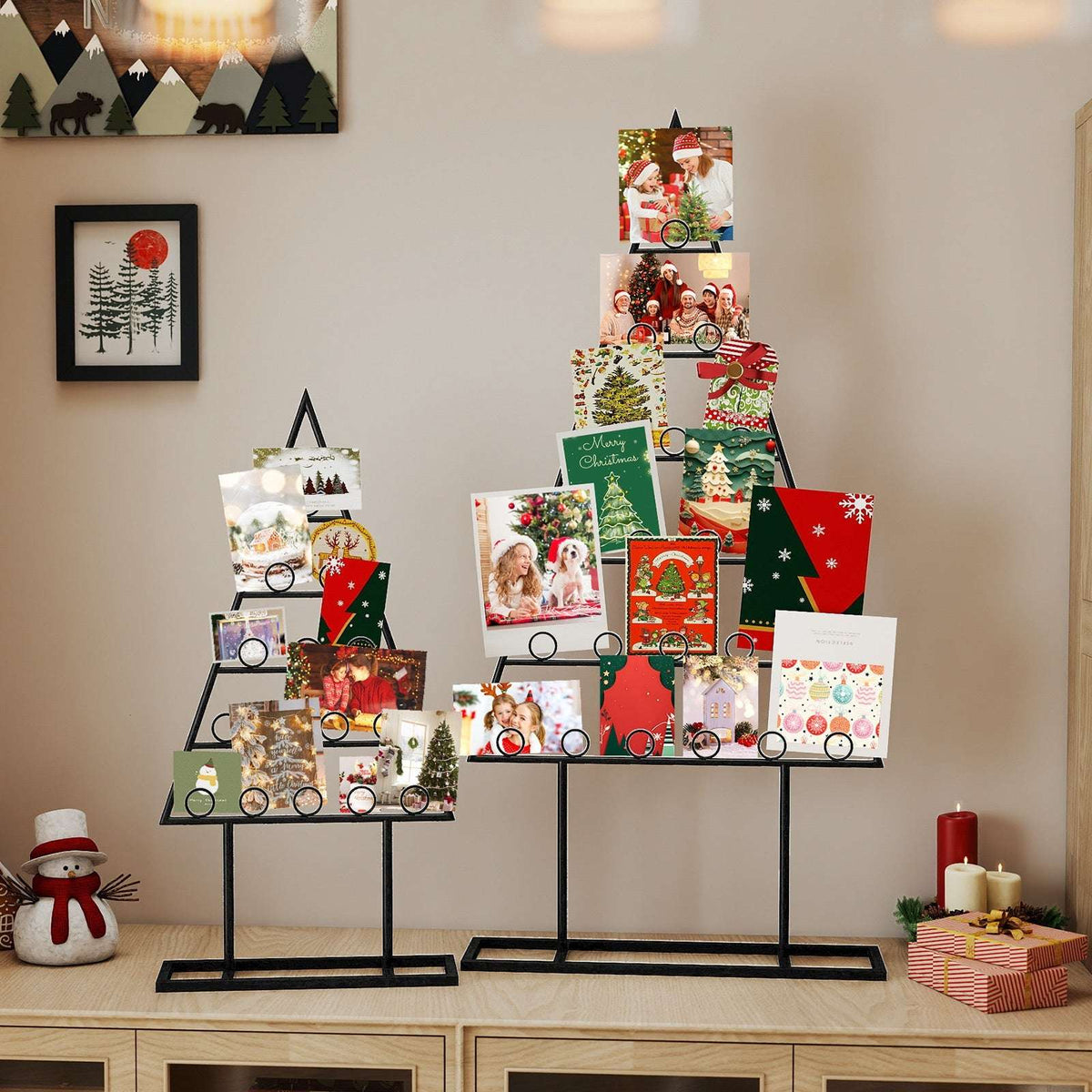 Two black metal Christmas tree photo holders displaying photos and Christmas cards.