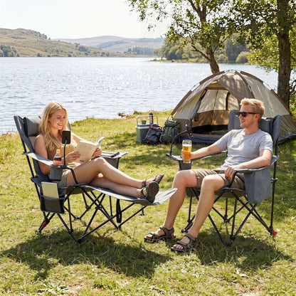 Grey reclining camping chairs with footrests, cup holders and side pockets beside a tent