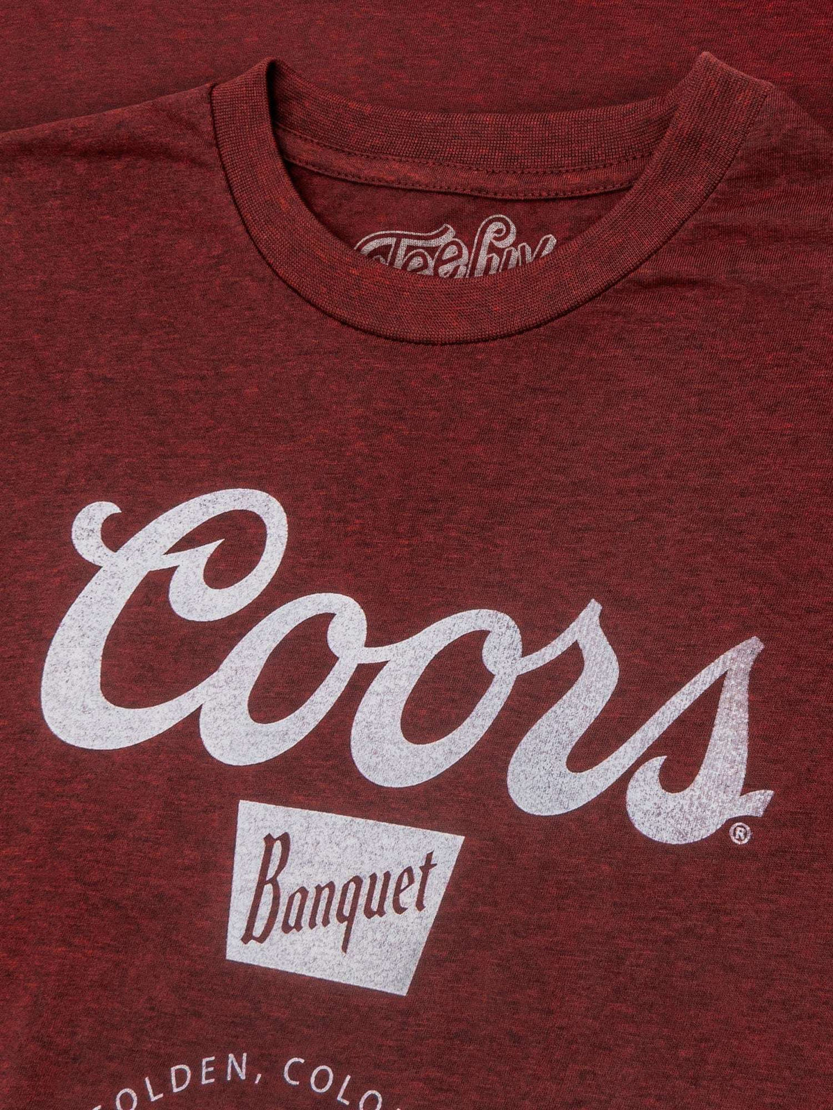 Red Coors logo T-shirt close-up with “Coors Banquet” chest print and “Golden, Colorado”.