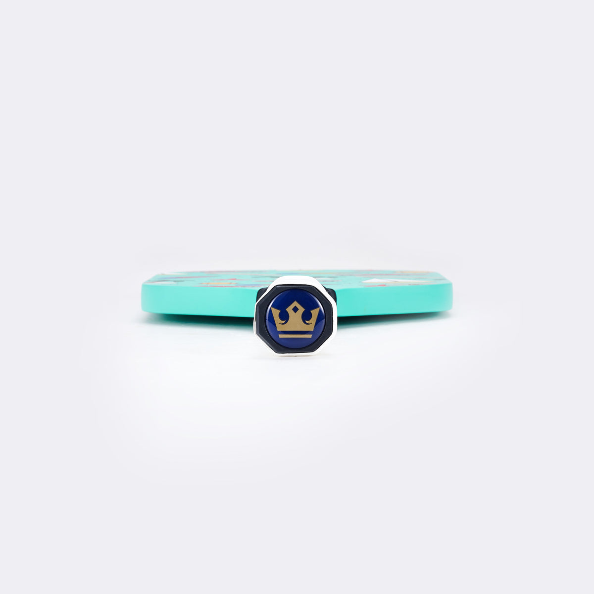 Pickleball paddle end view with mint edge and blue brand emblem on face.