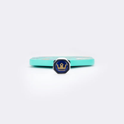 Pickleball paddle end view with mint edge and blue brand emblem on face.