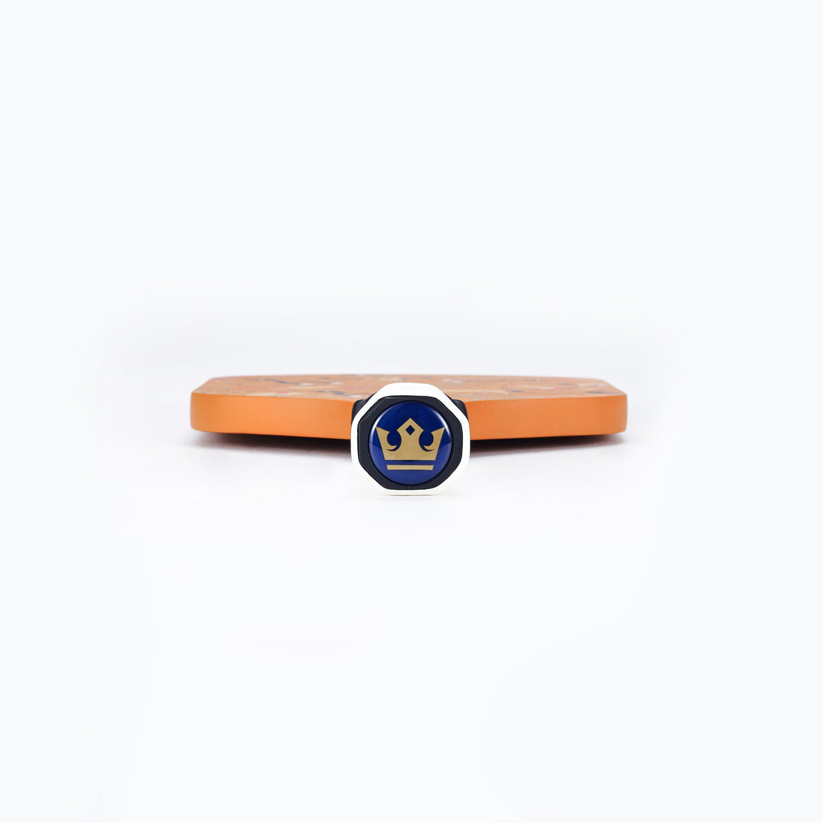 Orange pickleball paddle edge with blue circular logo medallion