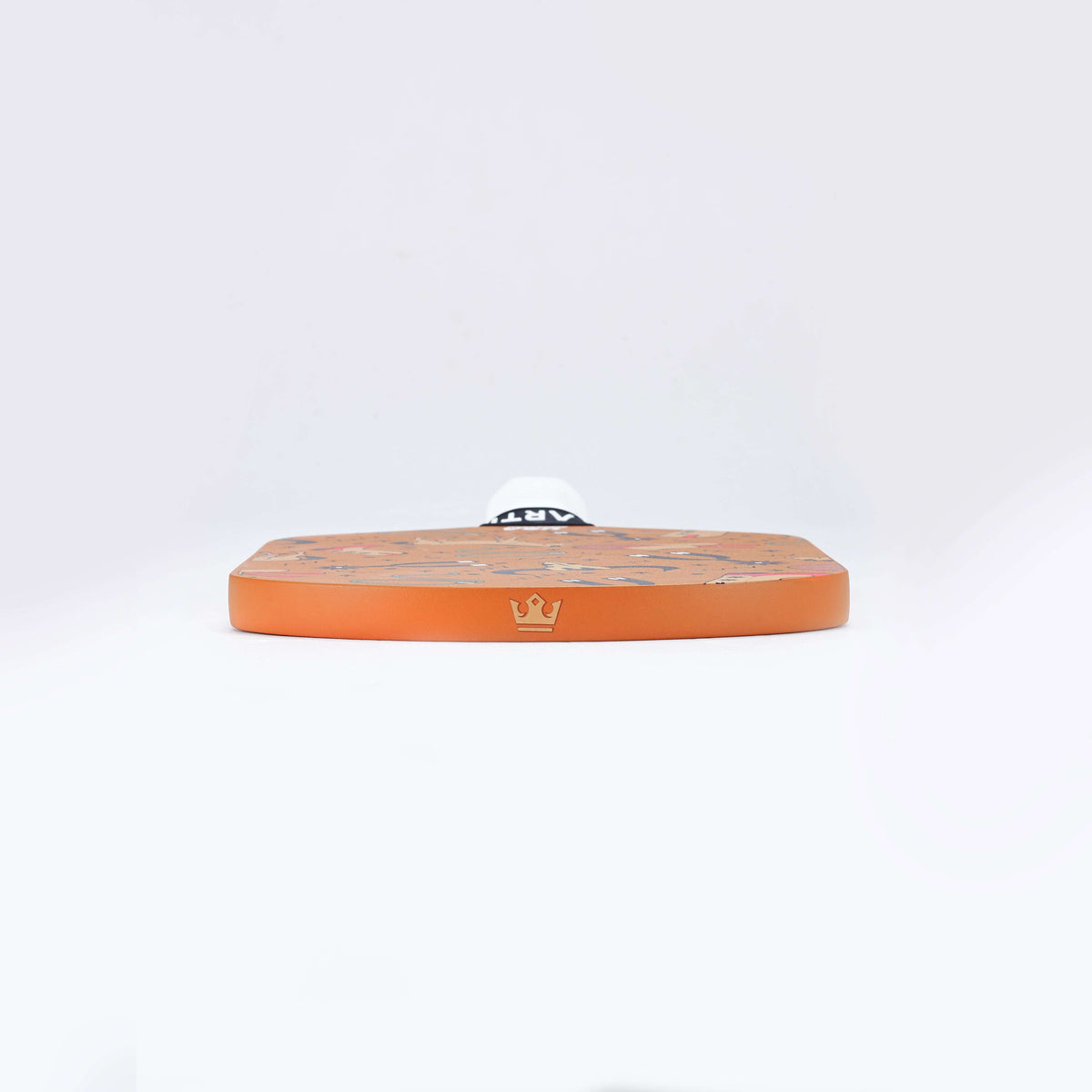 Orange pickleball paddle lying flat, showing thick edge and white grip