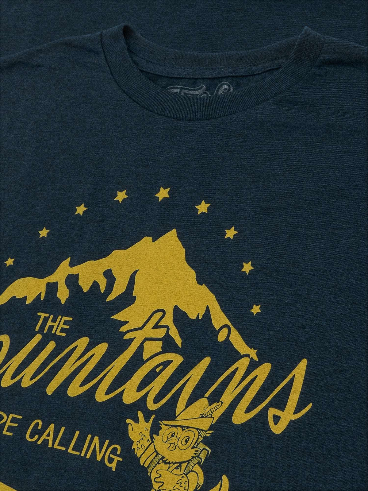 Navy T-shirt front close-up featuring yellow mountains, stars, and “The Mountains” text