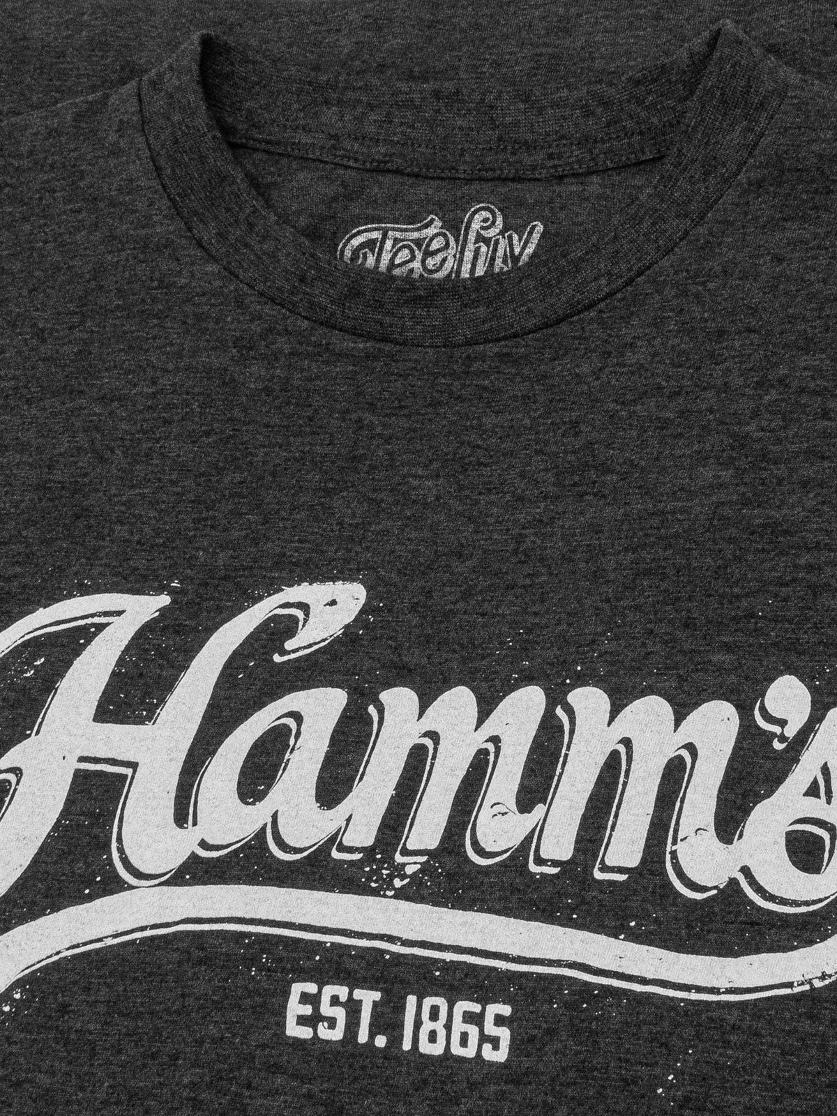 Charcoal heather T-shirt neckline with Teeluv label and partial Hamm’s logo print