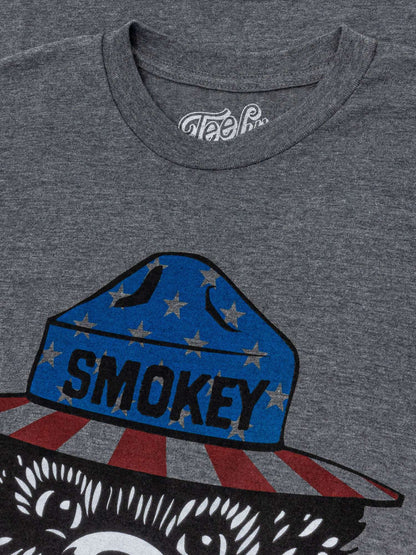 Gray t-shirt close-up of Smokey bear patriotic hat and stars graphic.