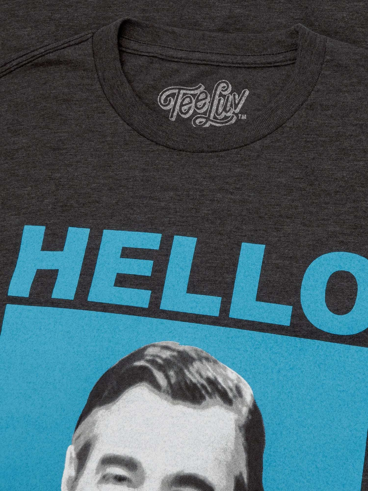 Gray T-shirt neckline with small 'Feelin' logo and partial blue 'HELLO' graphic print