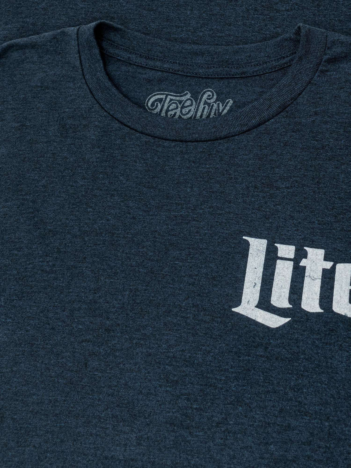 Denim black heather T-shirt neckline with "TeeLuv" logo and partial "Lite" print