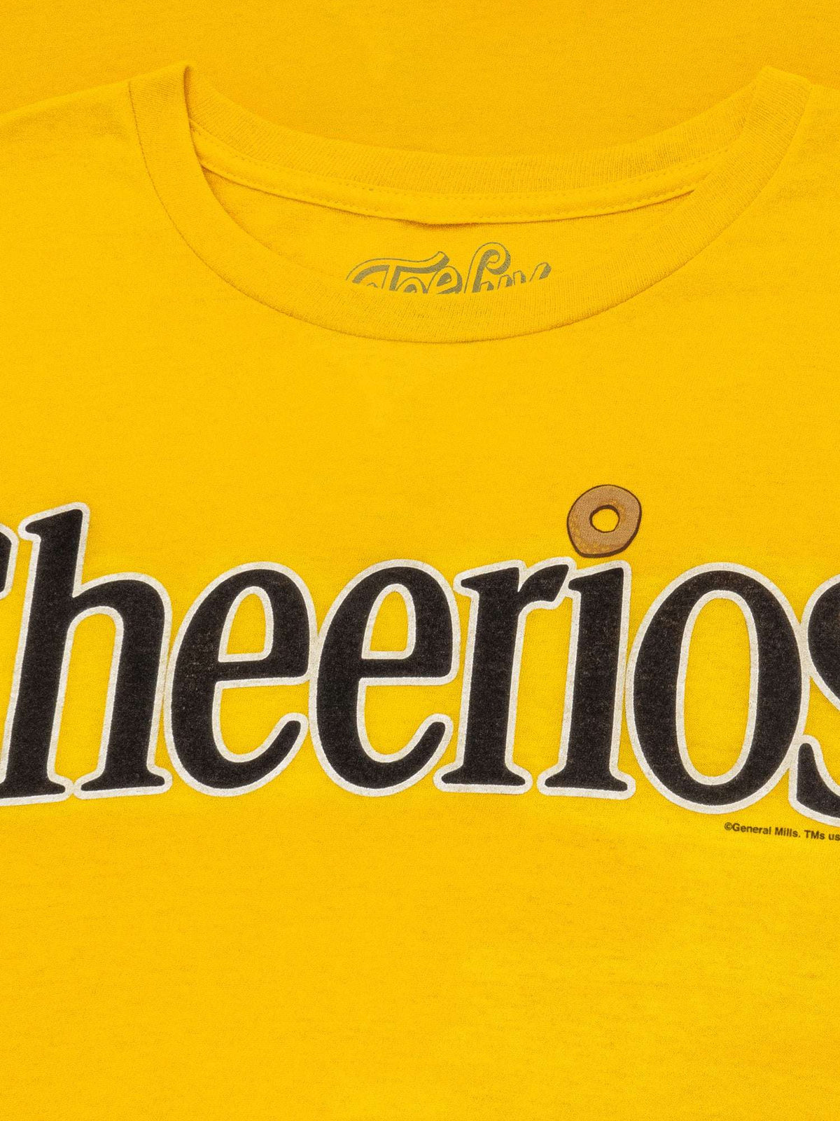 Yellow crew-neck T-shirt with partial Cheerios logo close-up