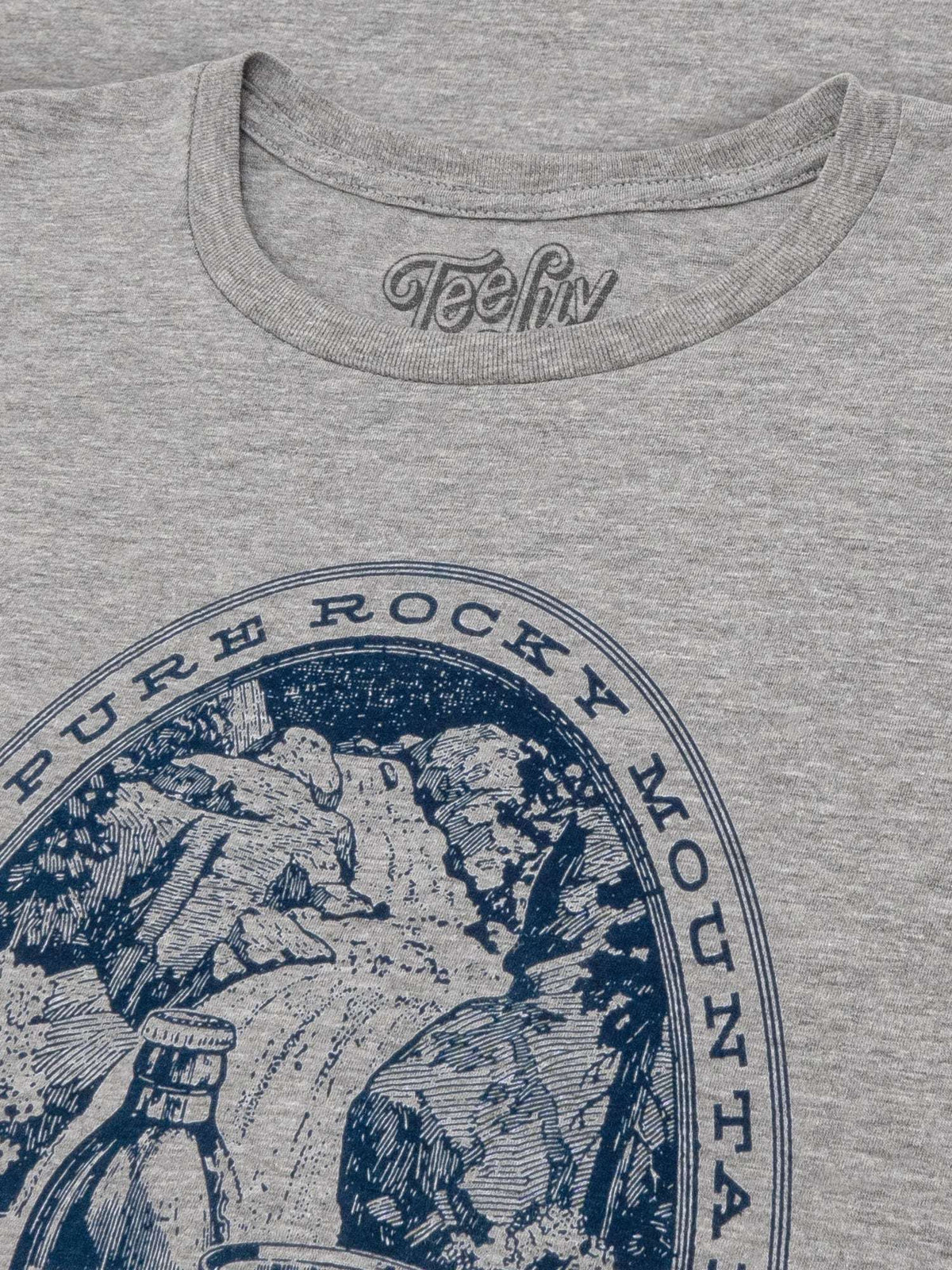 Gray T-shirt chest close-up with blue circular Rocky Mountain Water design