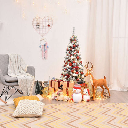 Snow-flocked pencil Christmas tree decorated with colorful ornaments
