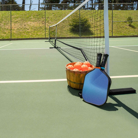 Portable pickleball net post with padded carry bag and corner base on court