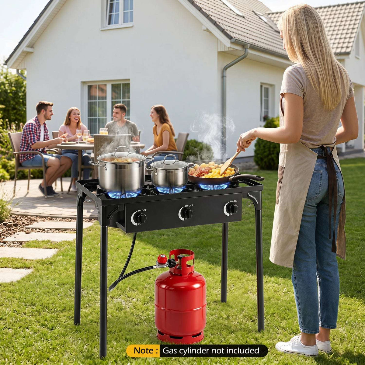 Three-burner propane stove with cookware, hose, and red gas cylinder.