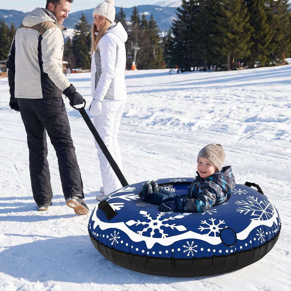 Blue inflatable snow tube with snowflake design and tow strap, child riding in snow