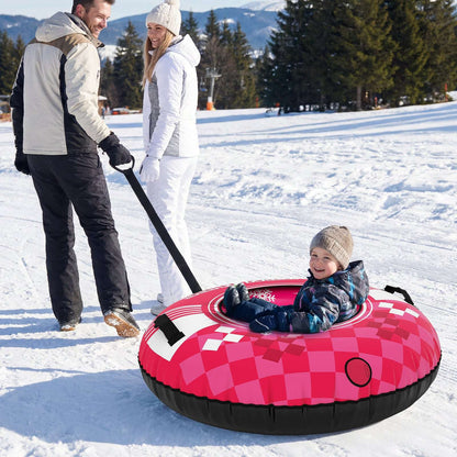 Red inflatable snow tube with snowflake design and tow strap, child riding in snow