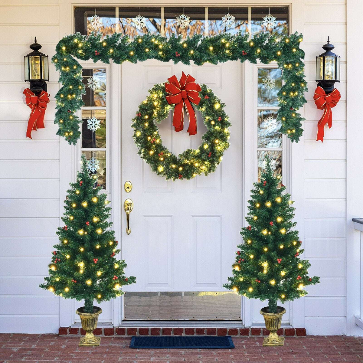 Pre-lit Christmas entrance set with two potted trees, wreath, and overhead garland