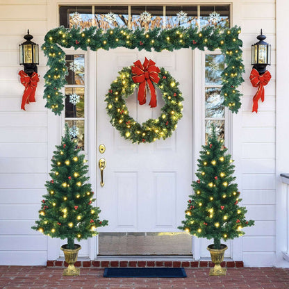 Pre-lit Christmas entrance set with two potted trees, wreath, and overhead garland