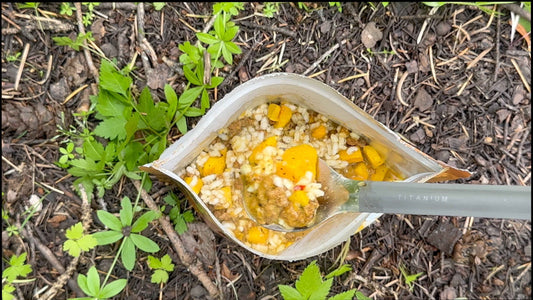 Spoonful of Italian sausage risotto freeze-dried meal in camp bowl
