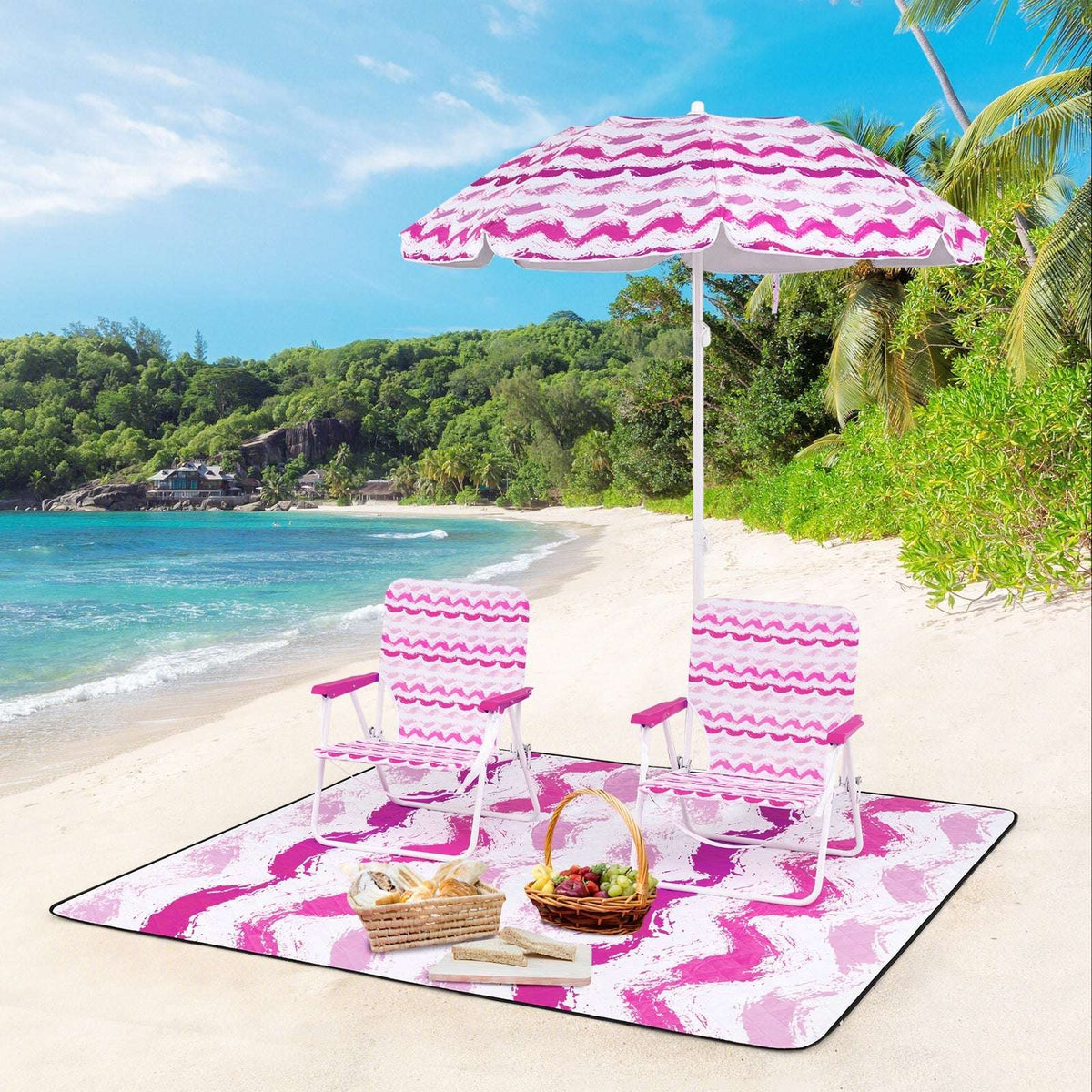Pink umbrella with two striped chairs and picnic blanket on the beach