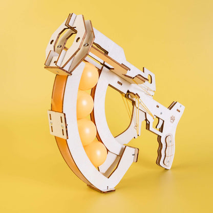 Wooden mechanical ball launcher kit with orange balls and slingshot frame