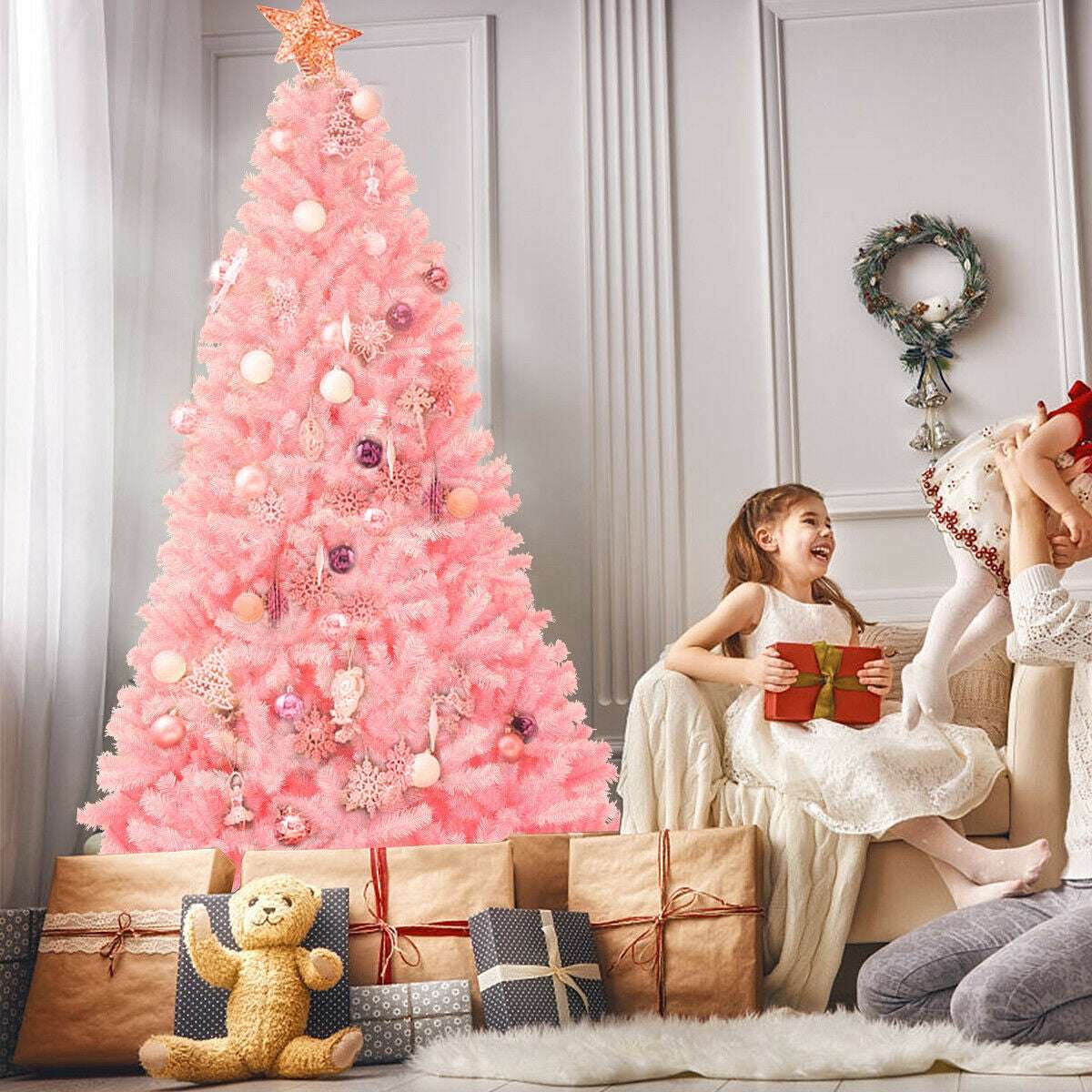 Pink artificial Christmas tree with a star topper and assorted ornaments